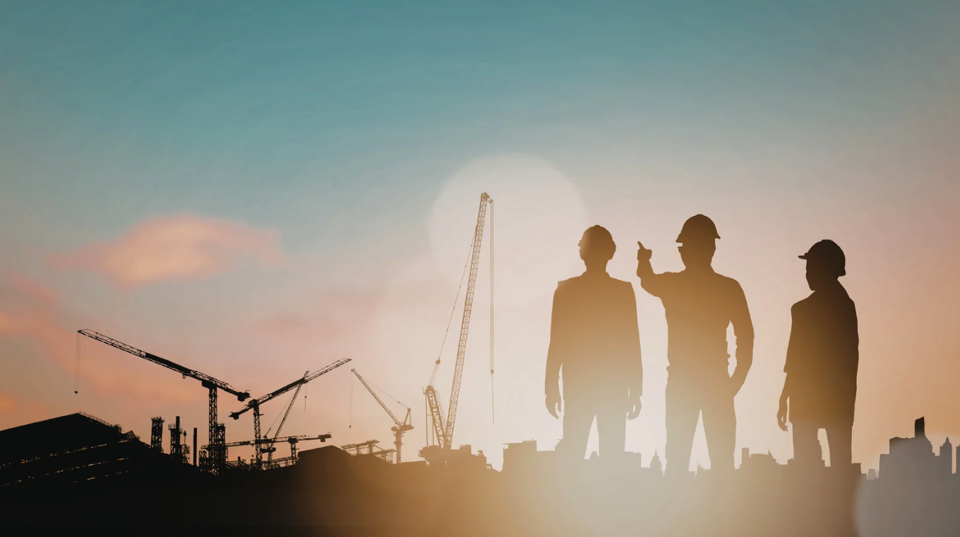 Construction workers on a job site at sunset
